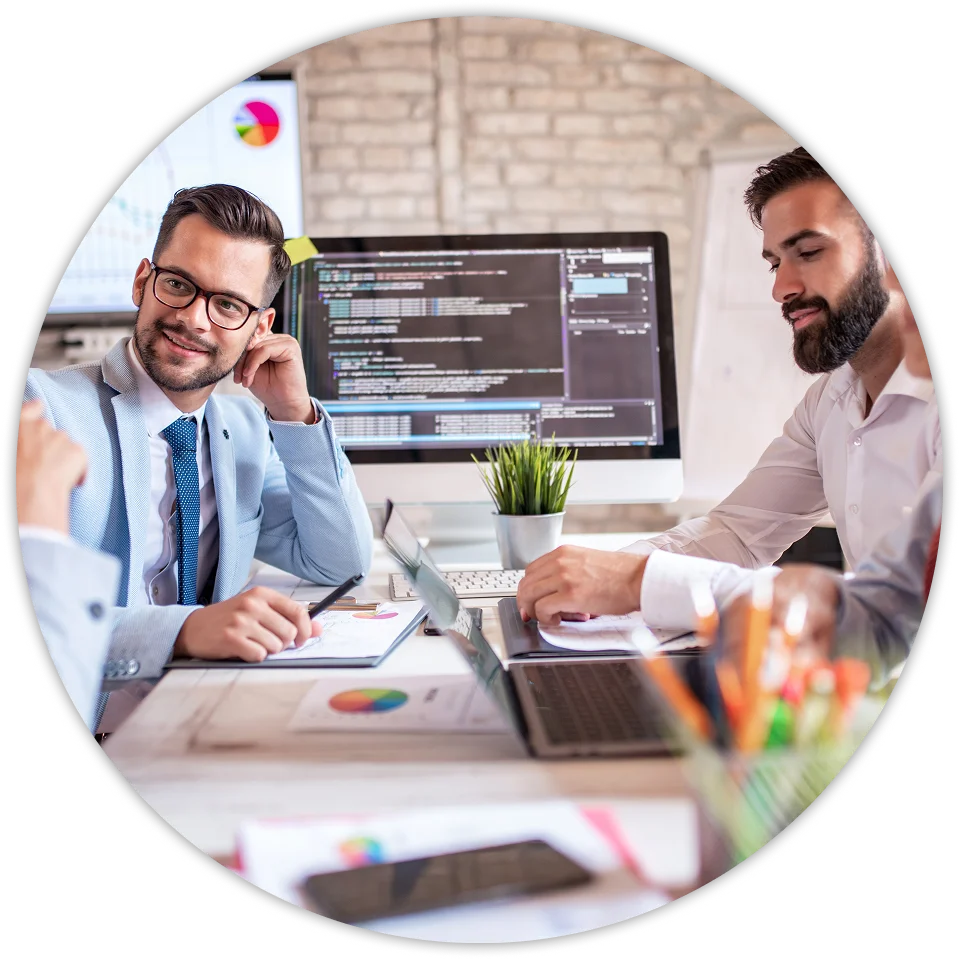 Group of people at a meeting with laptops and graphs